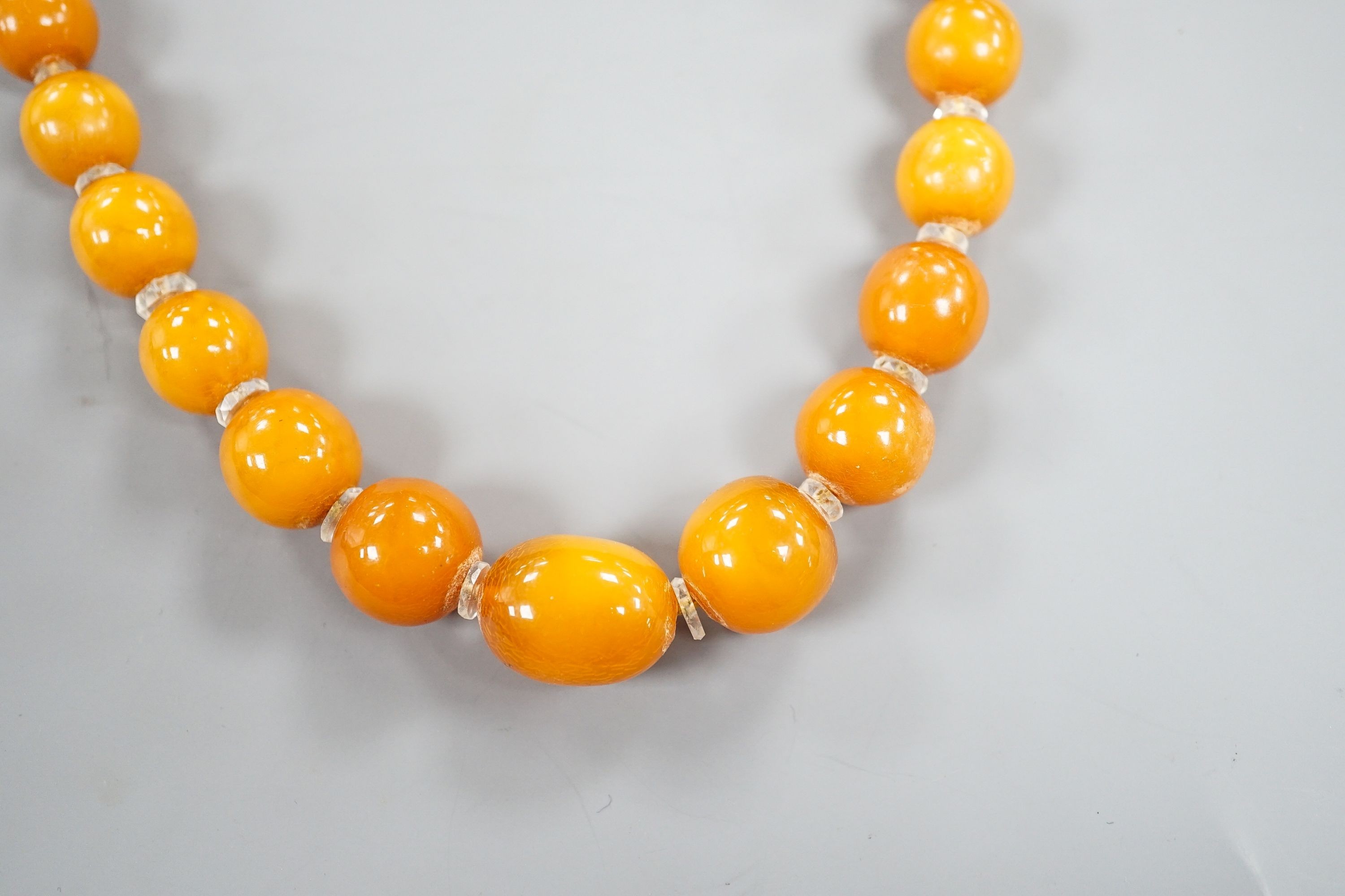 A single strand graduated amber bead necklace, with paste spacers, 42cm, gross weight 31 grams.